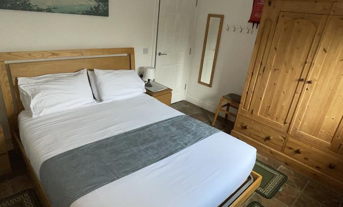 Shows positioning of pine wardrobe, king size bed, mirror, table lamps, and 2 bedside cabinets with lamps